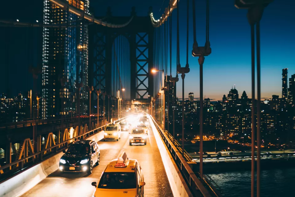 View of traffic on bridge going into Manhattan, New York City at night.
